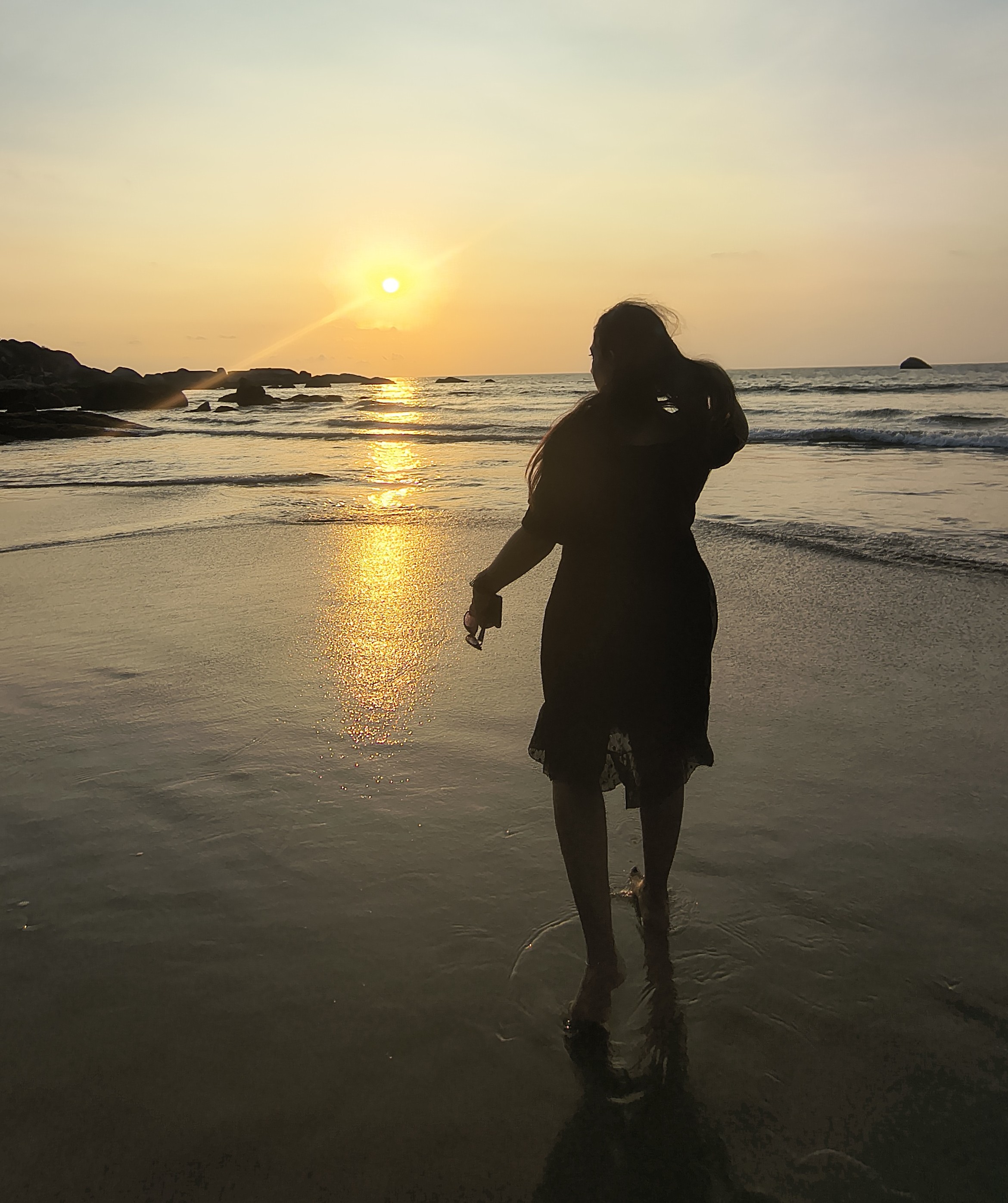 Vicky standing at the shore at sunset